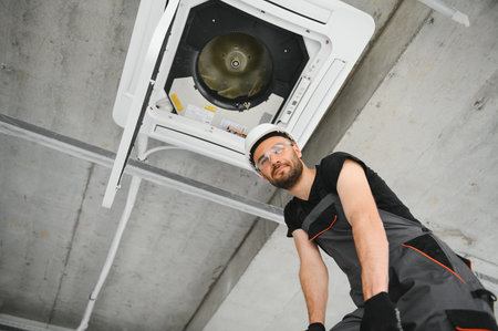 technician cleans air conditioner system in a modern apartment.