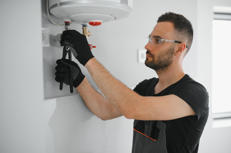 Professional plumber servicing a boiler.
