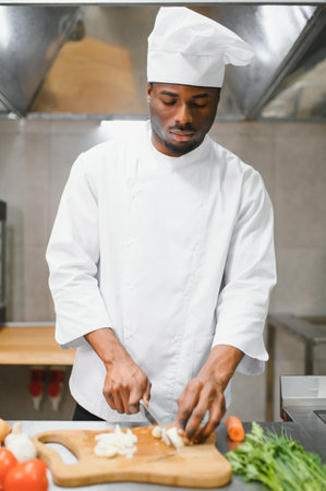 Portrait of happy African American male chef standing in restaurant kitchen.の写真素材