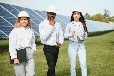 Male and female engineers worker working in solar panels power farm. technician working at solar...
