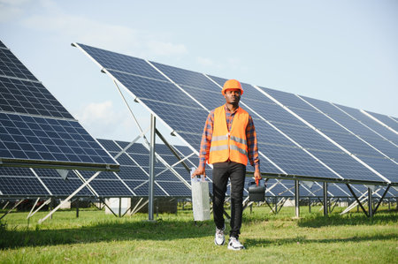 African American electrician worker installs solar panels. Green energy.の写真素材