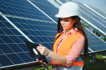 Beautiful young woman near solar panels outdoors.