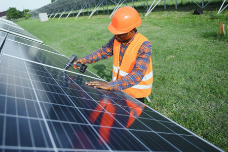 Portrait of African American electrician engineer in safety helmet and uniform installing solar...