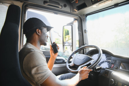 Professional driver sitting in truck cabin and driving.