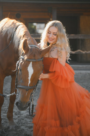 young woman in a dress with a horse.の写真素材