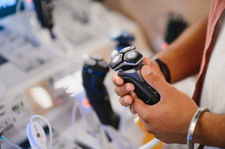Man choosing trimmer at electric storeの写真素材