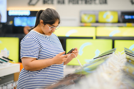 Indian woman choosing a new mobile phone in a shop.の写真素材