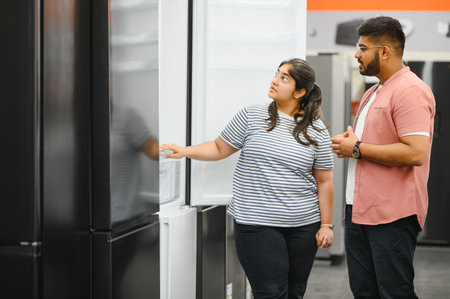 family couple buying domestic refrigerator in supermarket.の写真素材