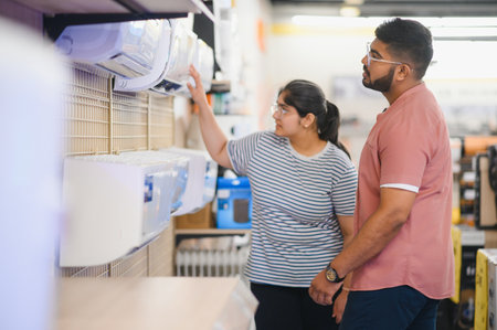 A beautiful couple chooses an air conditioner at home in an electronics store.の写真素材