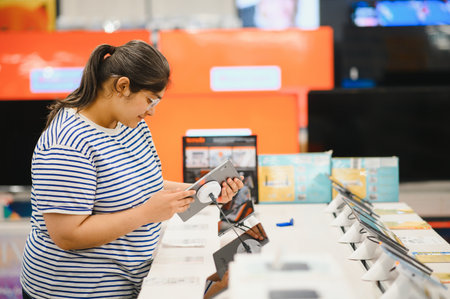 Smart modern female customer choosing coffee machine at electronics store.