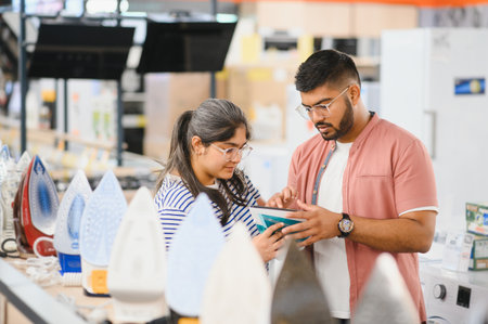 Couple standing in an electronics store choosing an electric iron for Ironing things, household...