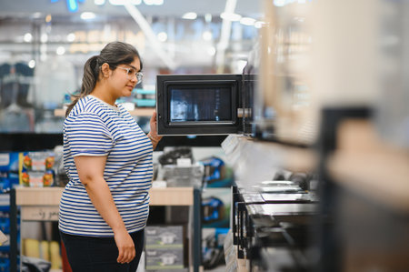 Woman shopping for microwave in appliances store.の写真素材