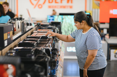 Smart modern female customer choosing coffee machine at electronics store.