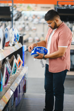 Man choosing electric iron at storeの写真素材