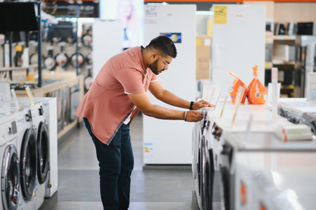 Indian man choosing washing machine at electronics store.の写真素材