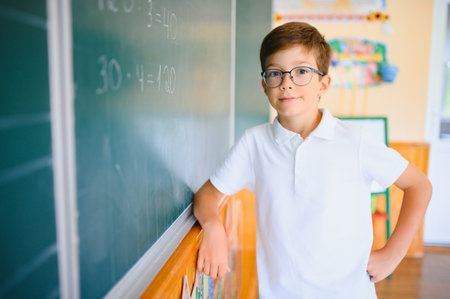 Photo of cute little schoolboy diligent write chalk solve math problem dressed stylish uniform...