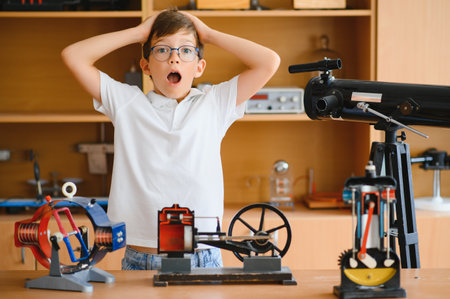 Physics lesson. A student at a desk with scientific instruments and a telescope.の写真素材