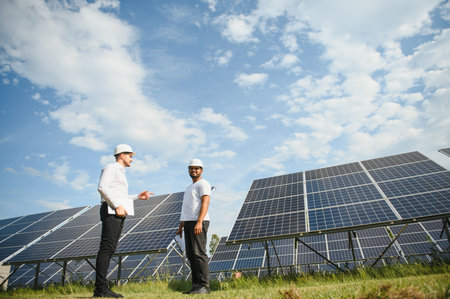 Two engineers or businessmen on the background of solar panels. Renewable energy. Green energy.の写真素材
