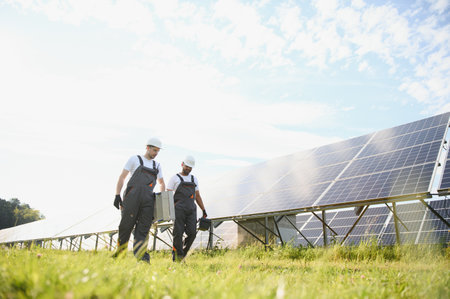 A team of two engineers are working to install solar panels at a solar power station. Engineer team...