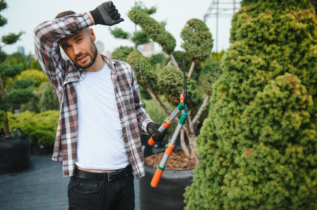 Portrait of a young handsome gardener. Shop of tree sproutsの写真素材
