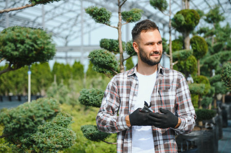 Garden Pruning Works to Maintain the Appearance of Shrubs, Bushes, Trees and Other Plants. Professional Landscaper Cutting the Overgrown Sprigs and Leaves with Garden Scissors.の写真素材