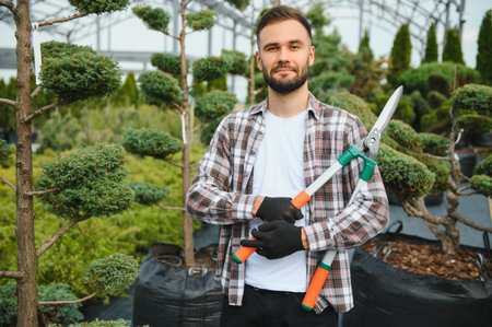Portrait of a young handsome gardener. Shop of tree sproutsの写真素材