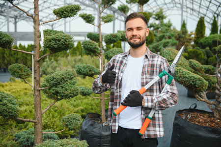 Portrait of a young handsome gardener. Shop of tree sproutsの写真素材