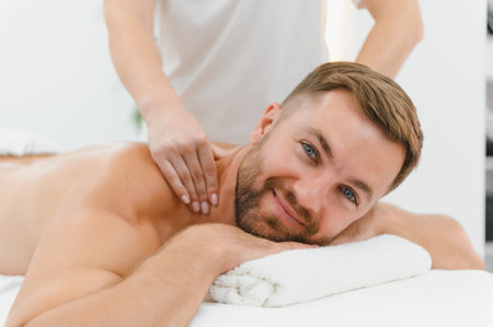Young man is enjoying massage on spa treatment.