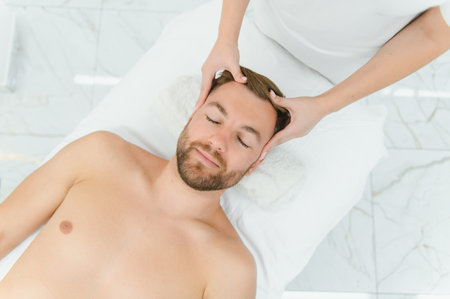 Handsome middle-aged man enjoying relaxing spa massage with oils.の写真素材