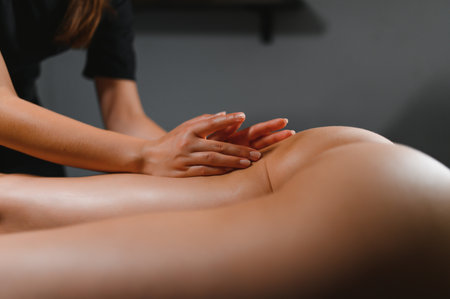 Beauty treatments for weight lost. Cropped shot of therapist or massager doing lymphatic drainage or anti cellulite massage on legs for woman client lying at spa center. Body care conceptの写真素材