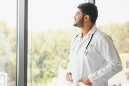 Portrait of male Indian doctor on clinic corridor as background.の写真素材