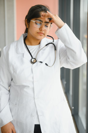 Portrait of tired female doctor in clinicの写真素材