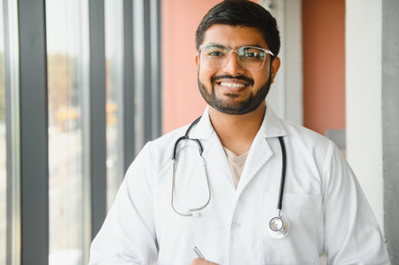 Young Indian male professional doctor wear white medical uniform with stethoscope.の写真素材