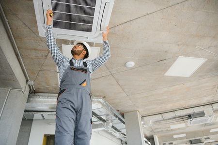 Professional maintaining technician modern air conditioner indoors. Space for text.の写真素材