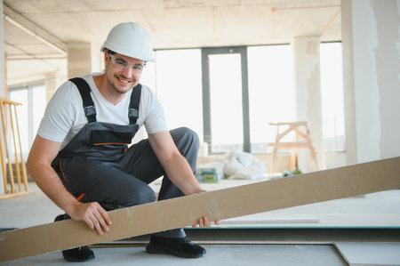 male construction worker wearing uniform Install gypsum ceiling inside the house and building.
