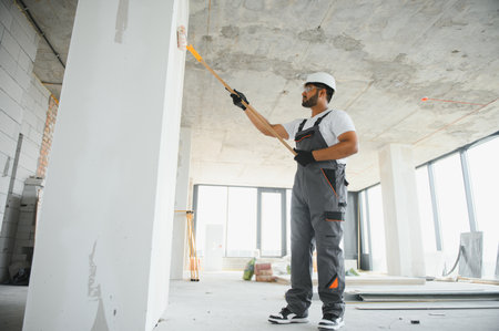 painter doing painting work on wall with roller. concept of hard working, home renovation.