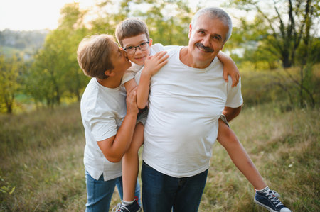 Grandparents and grandson together in autumn park.の写真素材
