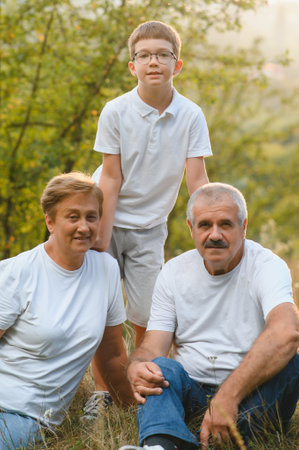 Grandparents and grandson together in autumn park.の写真素材