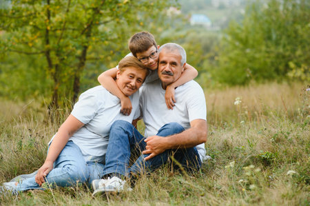 Grandfather grandmother and grandson having fun outdoors in park.
