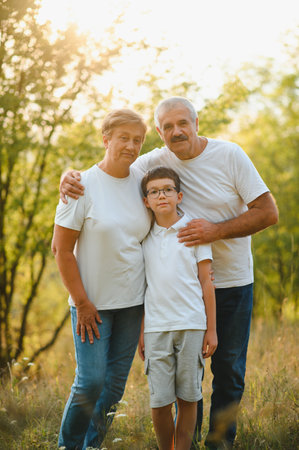 Grandfather grandmother and grandson having fun outdoors in park.