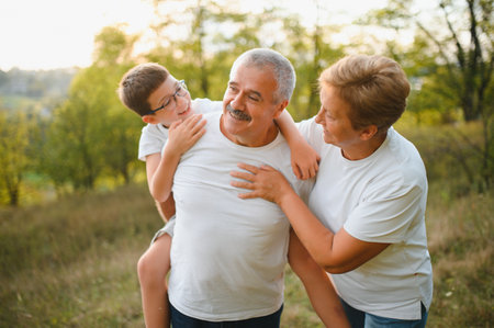 Grandparents and grandson together in autumn park.の写真素材