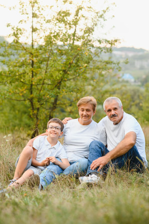 Grandparents and grandson together in autumn park.の写真素材