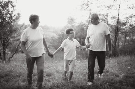 Grandfather grandmother and grandson having fun outdoors in park.の写真素材