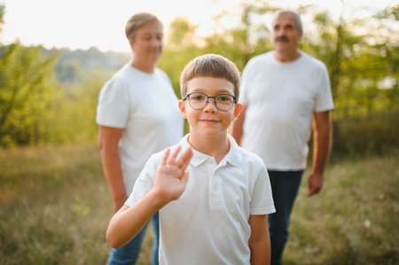 Grandparents and grandson together in autumn park.