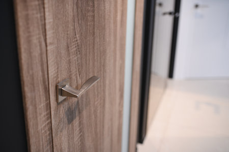 Wooden interior door with emphasis on metal handle. Close up of door handle on interior door.の写真素材