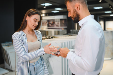 Young woman with sales man choosing tiles at building market.の写真素材
