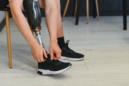 Closeup of unrecognizable man with bionic prosthetic leg at home indoors, copy space.