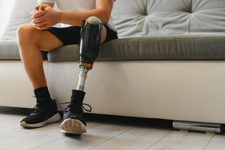 Closeup of unrecognizable man with bionic prosthetic leg at home indoors, copy space.の写真素材
