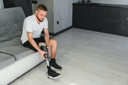 Portrait of a young man with a prosthetic leg at home.