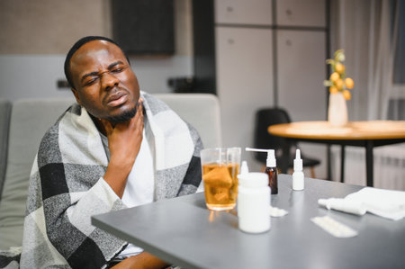 Sick African man with sore throat Portrait of ill black man suffering from sore throat due to cold, flu, allergy, polluted air, dust, smog air pollution sickness concept African man modelの写真素材